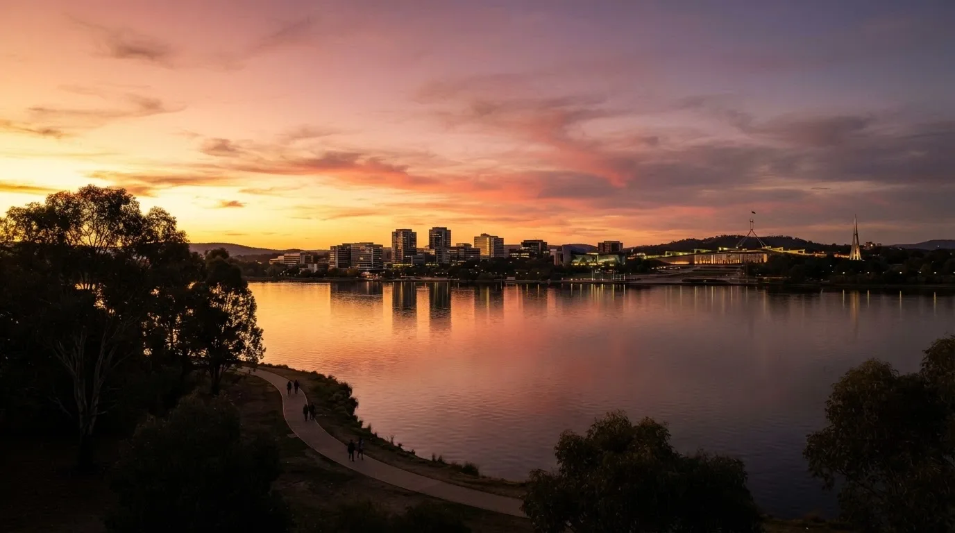 A wide shot of Lake Burley Griffin at sunset with the Canberra CBD skyline including Casino Canberra's precinct in the distance, the city calm after dark